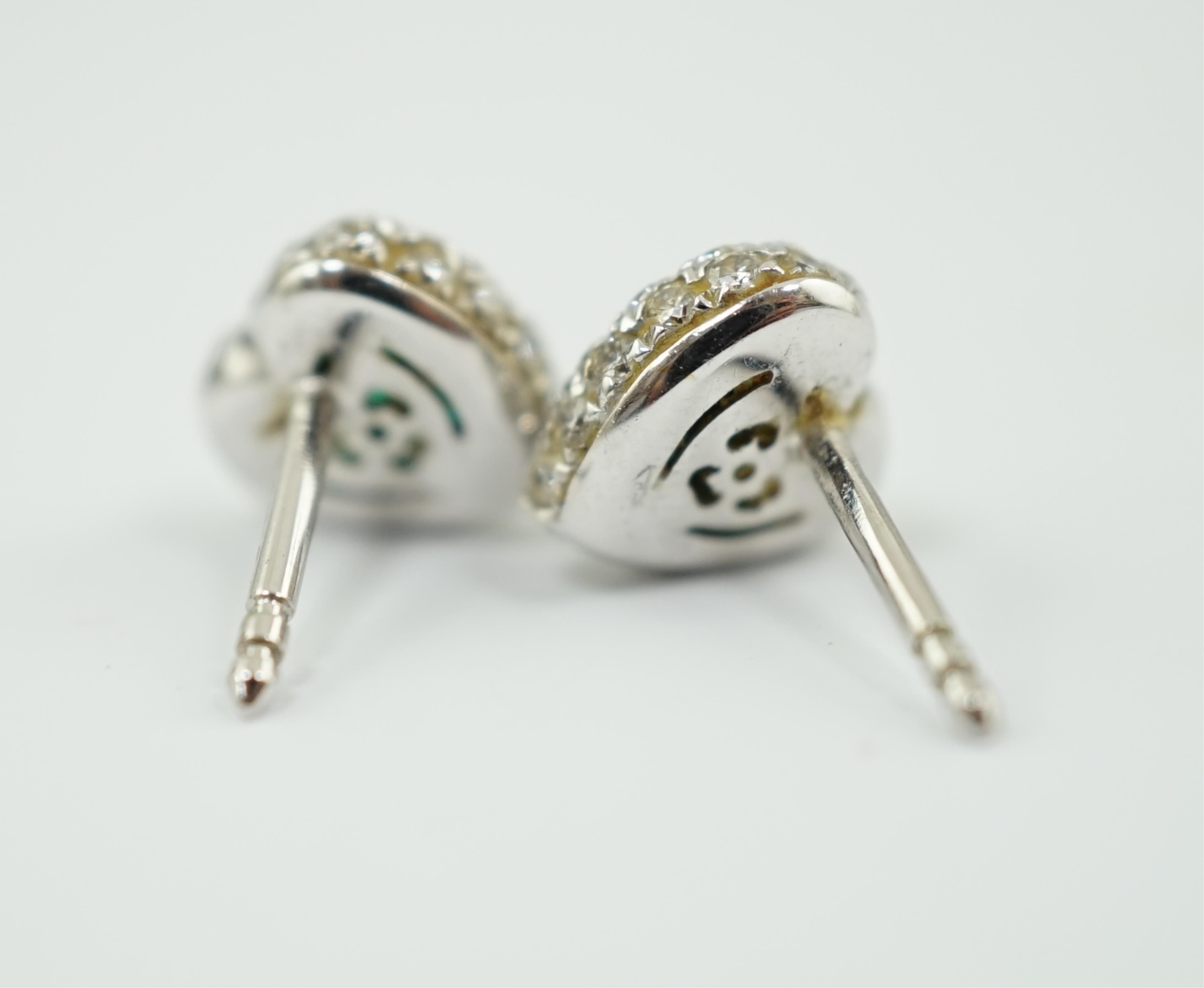 A modern pair of 18ct white gold, emerald and diamond set heart shaped cluster ear studs